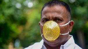 Un Indien porte un masque en or pour se protéger du coronavirus